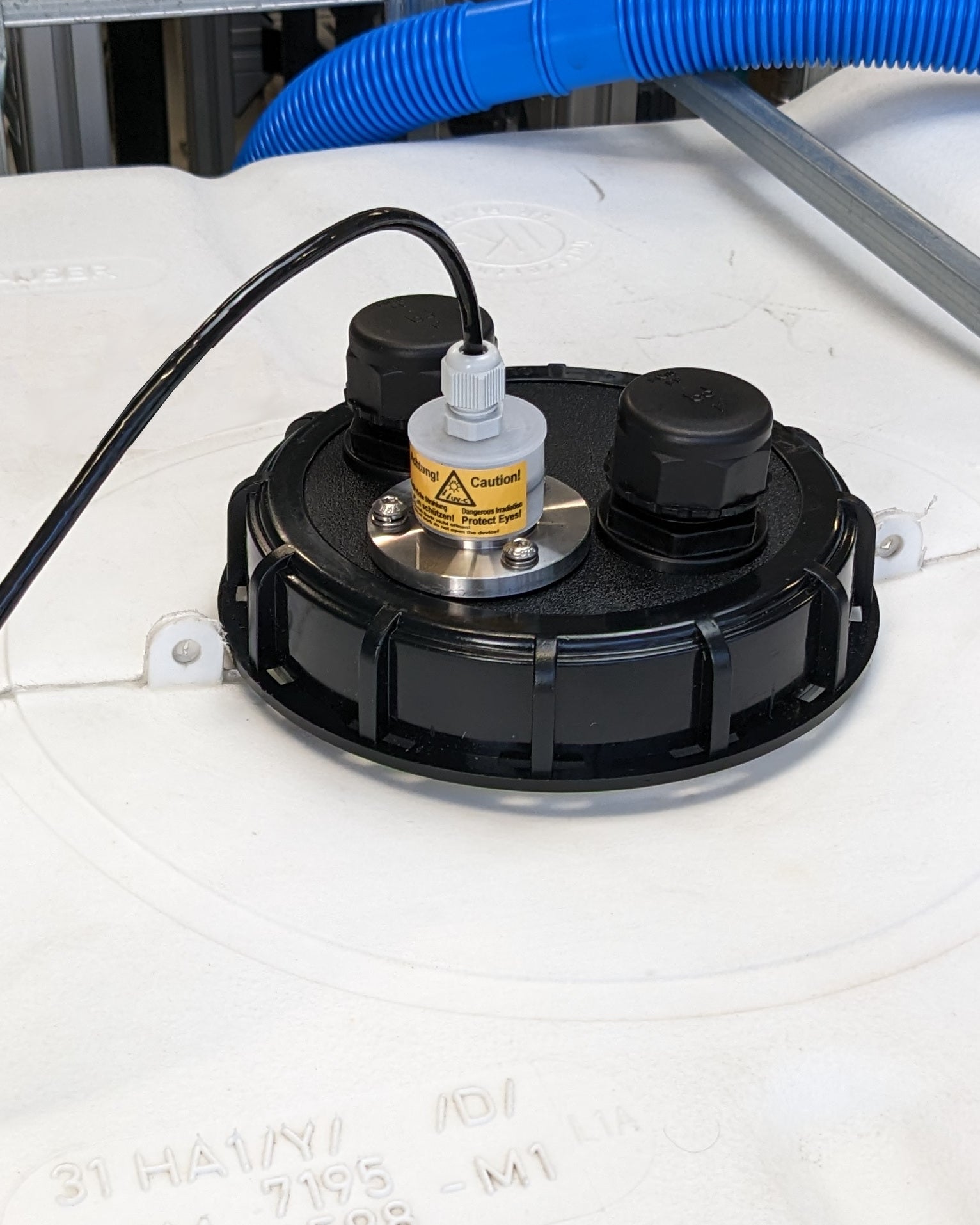 Ein UV Concept GmbH PURION IBC DN150 36W OTC SPL BS Tankset mit daran befestigtem Schlauch sorgt für hochwertige Trinkwasserqualität bei der Wasserentnahme.