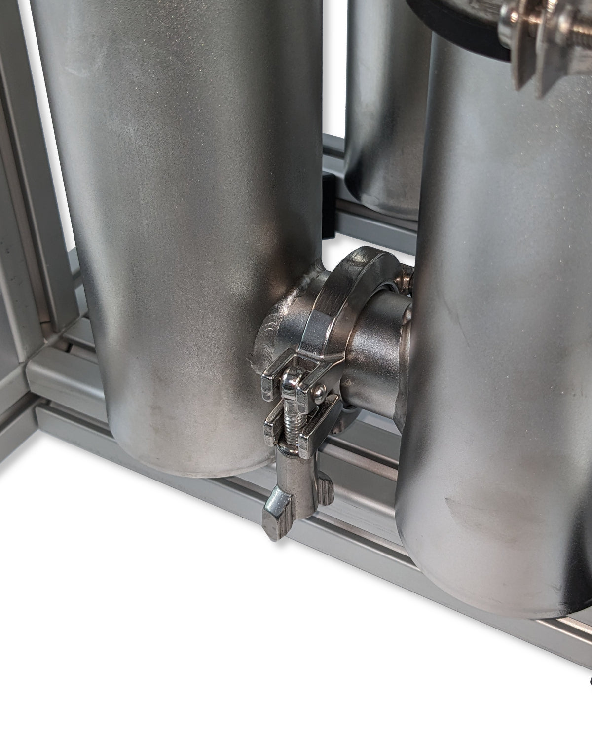 Ein PURION 4x 2501 Edelstahl-Wasserfiltersystem mit UV-Desinfektion und Verteilerrohren sowie einem daran angeschlossenen Schlauch für Wasserein- und -ausgang.