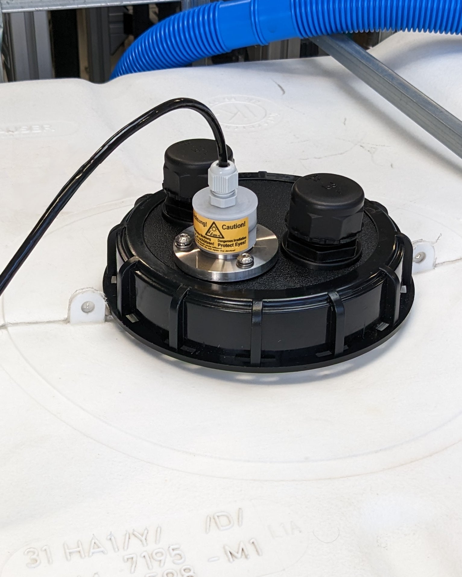 Eine Maschine mit angeschlossenem Schlauch, die hilft, Verkeimungen aus trübem Wasser oder leerem Tank effizient zu entfernen, ist die PURION IBC DN150 90W OTC SPL BS der UV Concept GmbH.